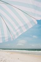 Blauw witte parasol op het strand