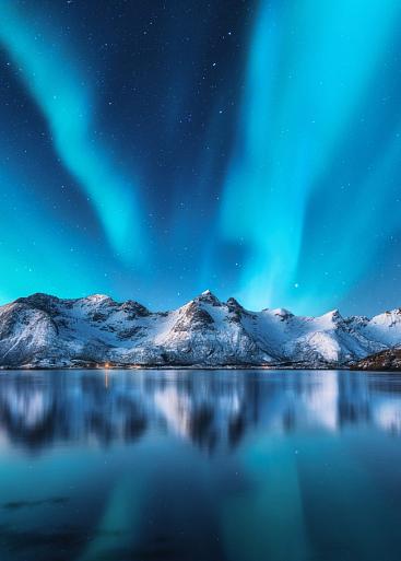 Besneeuwde bergen met Noorderlicht op de Lofoten-eilanden, Noorwegen
