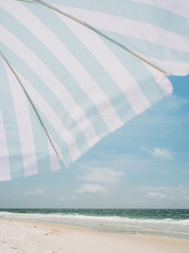 Blauw witte parasol op het strand