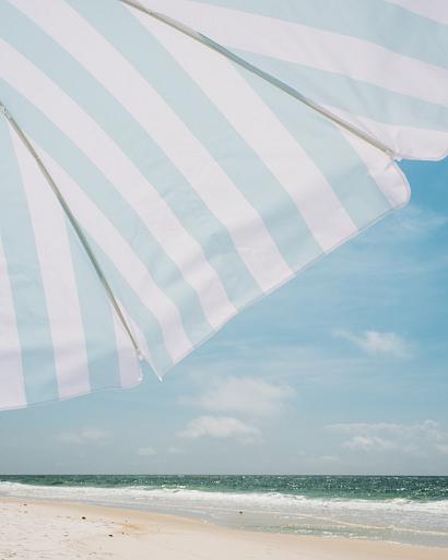 Blauw witte parasol op het strand
