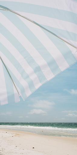 Blauw witte parasol op het strand