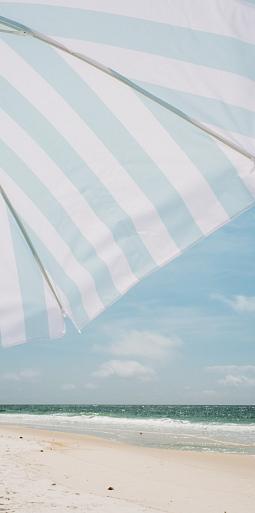 Blauw witte parasol op het strand