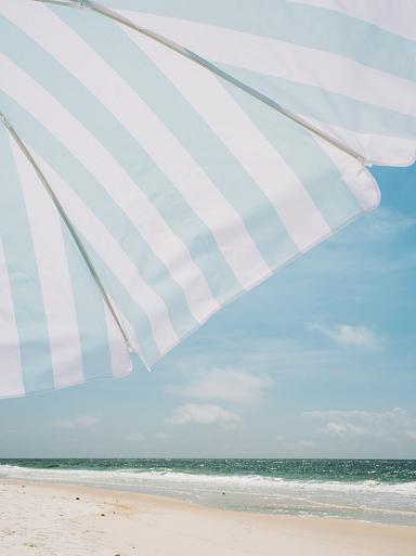 Blauw witte parasol op het strand