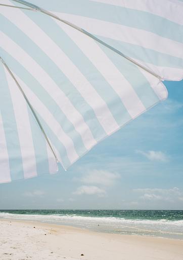 Blauw witte parasol op het strand